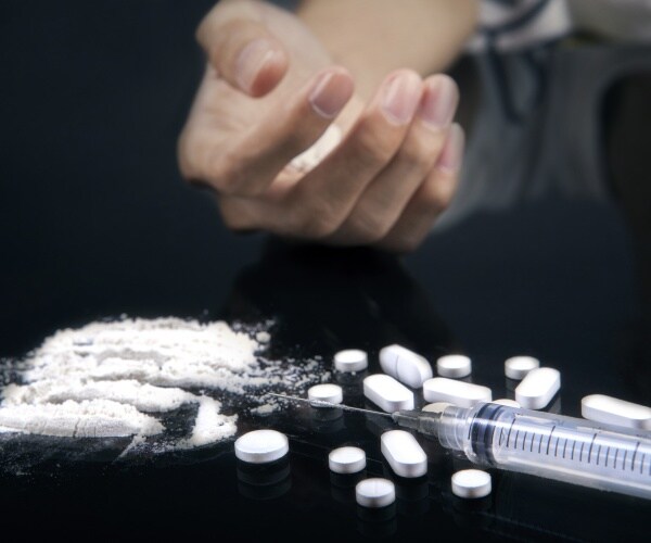 pills being cut to inject, hand, syringe