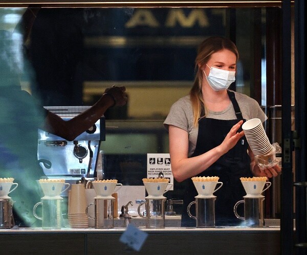 employee wears mask while working in coffee shop