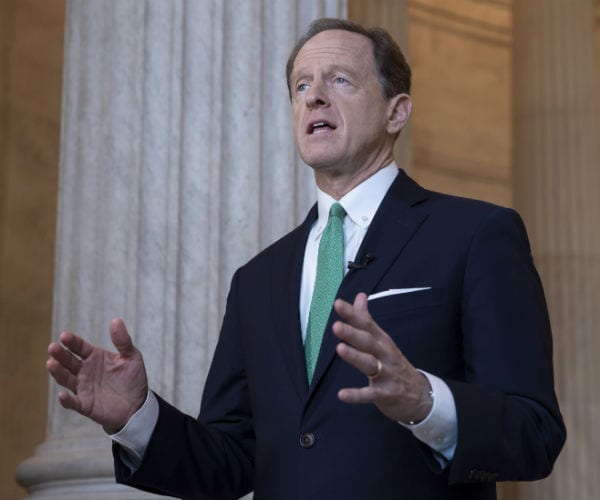 sen. pat toomey is shown in a suit, white dress shirt and green tie