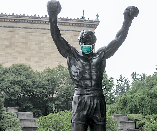 the famed rocky statue in philadelphia is shown with a mask on during the global coronavirus pandemic