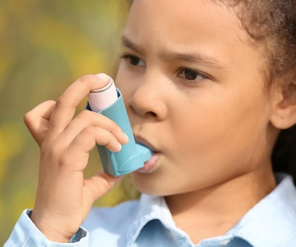 child using an inhaler for asthma