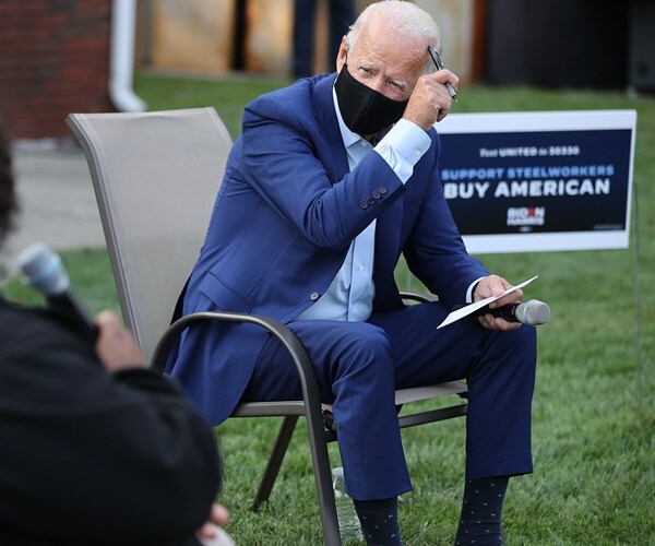 joe biden speaks under a biden harris sign