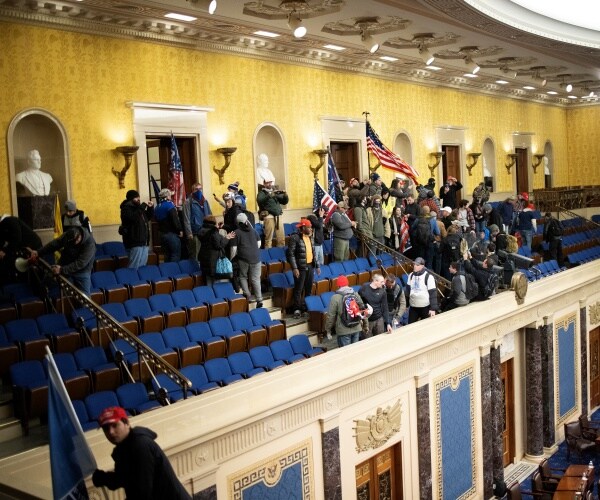 people walk through the gallery in the senate with flags