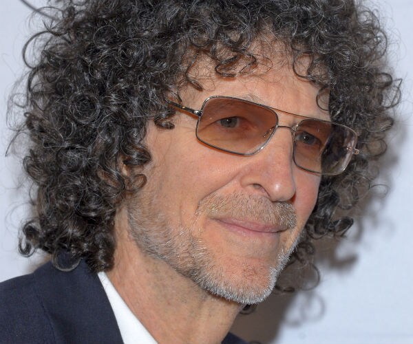 howard stern is seen in a blue suit, matching tie and white dress shirt