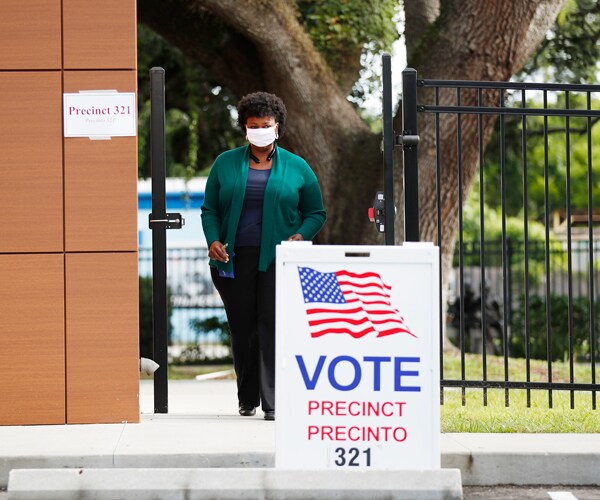 a voter wearing a mask exits a polling place in florida