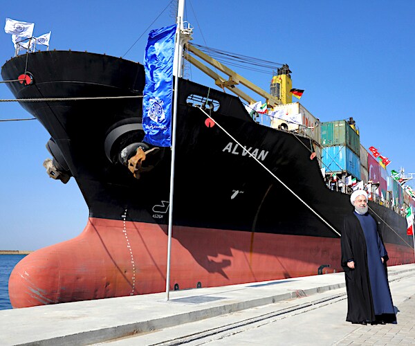 Iranian President Hassan Rouhan poses in front of an oil tanker