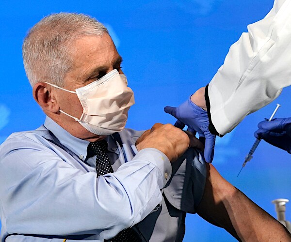 anthony fauci raises his left sleeve to take the first dose of the moderna vaccine