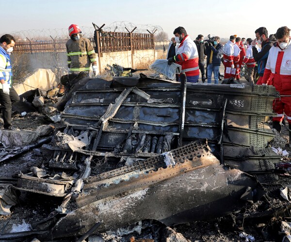 rescue workers at the site of a january 8 plane crash in ukraine