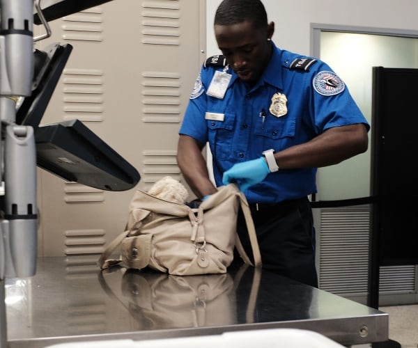 tsa officer checks a bag at the airport