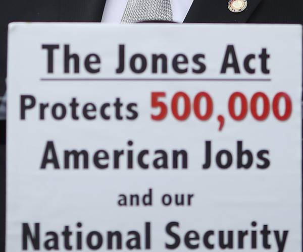 sign in front of podium says jones acts saves five hundred thousand american jobs and our national security