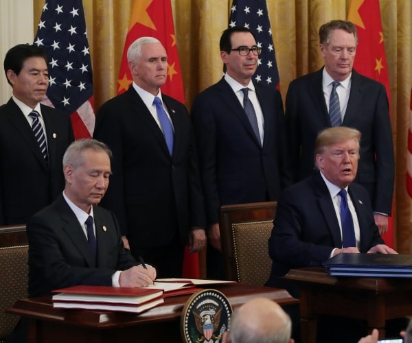 trump and liu he sign a trade deal in front of chinese and american flags with pence and mnuchin behind them