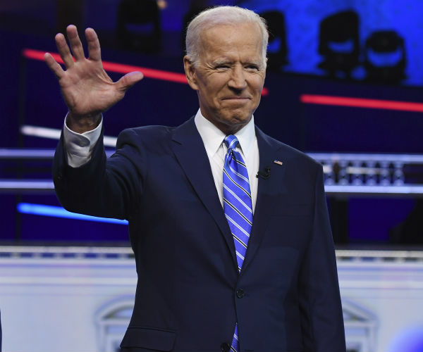 former vice president and democratic presidential candidate joe biden in blue suit, white shirt and blue stripped tie