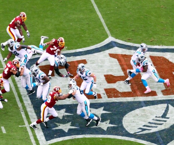 professional football game, NFL insignia in middle of field