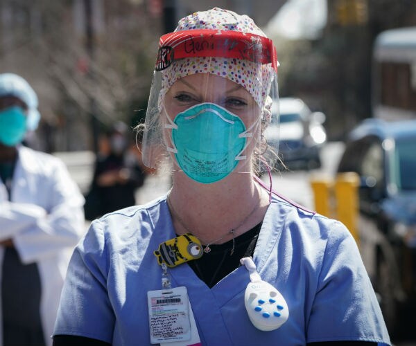 a nurse is shown wearing a face guard and n95 mask