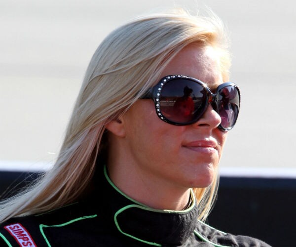 nascar driver candace muzny is shown in her racing suit and bedazzled sun shades