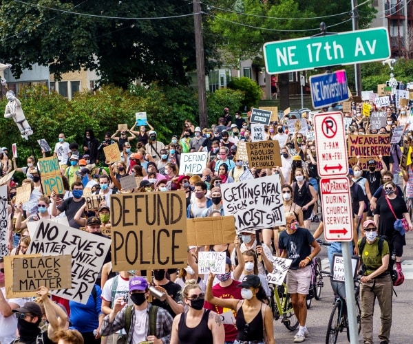 protesters hold up signs in a blm march