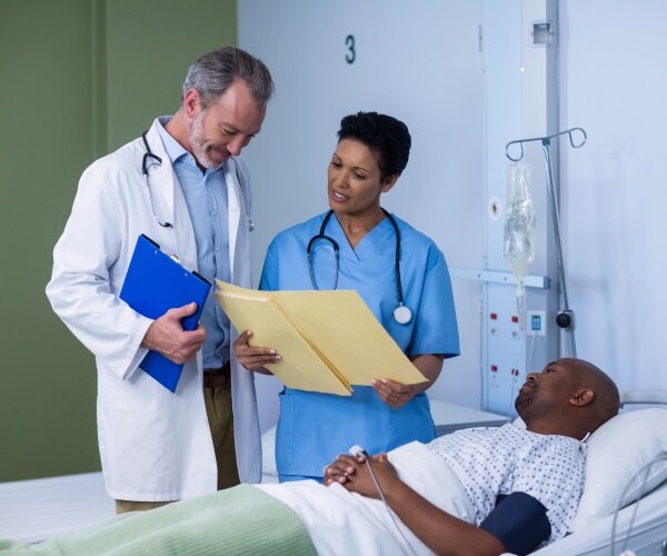 doctor and nurse look at a patient's records