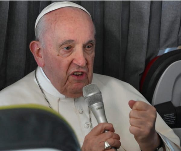 Pope Francis speaks into a microphone