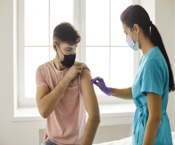 young man receives covid vaccine