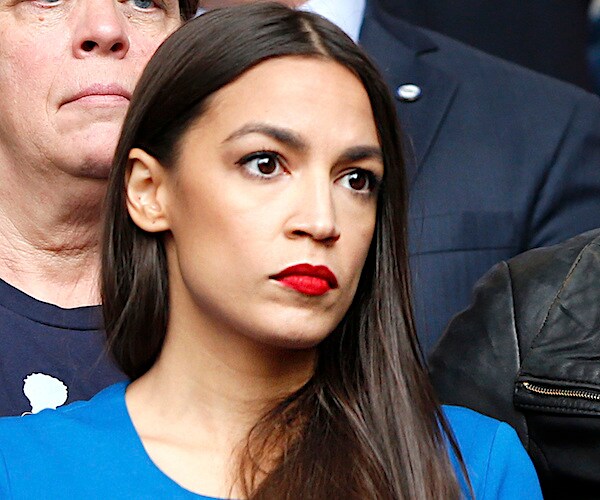 new york democratic representative alexandria ocasio-cortez wearing a blue blouse and bright red lipstick