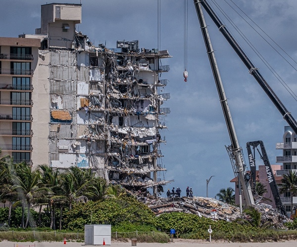 search and rescue team stands in rubble