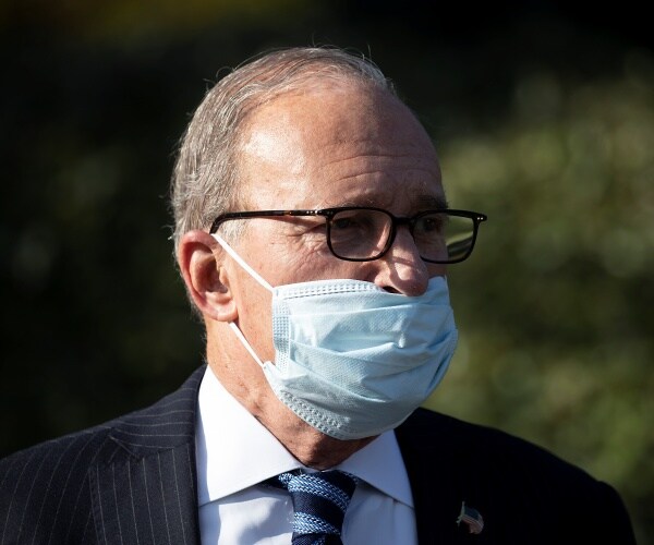 larry kudlow stands in driveway