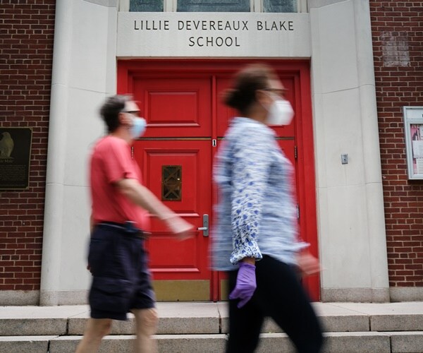 people walk past a closed public school in manhattan