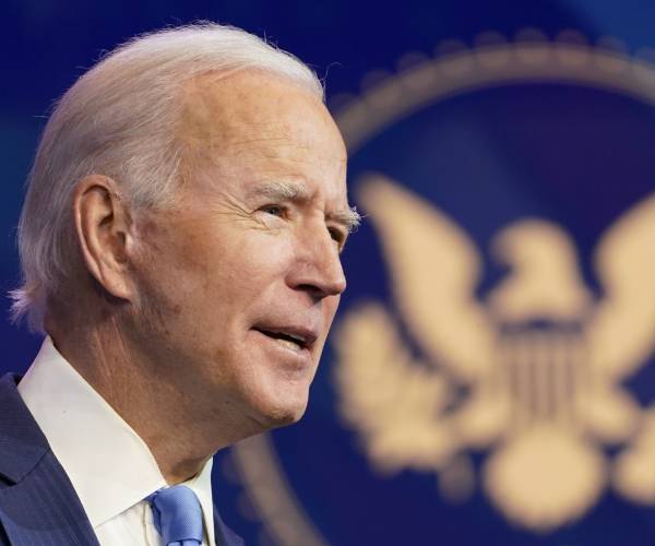 joe biden making a speech in front of the presidential seal