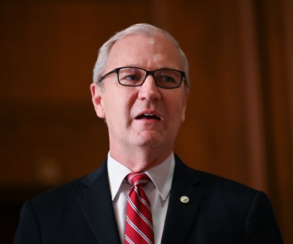 cramer in a black suit and red striped tie