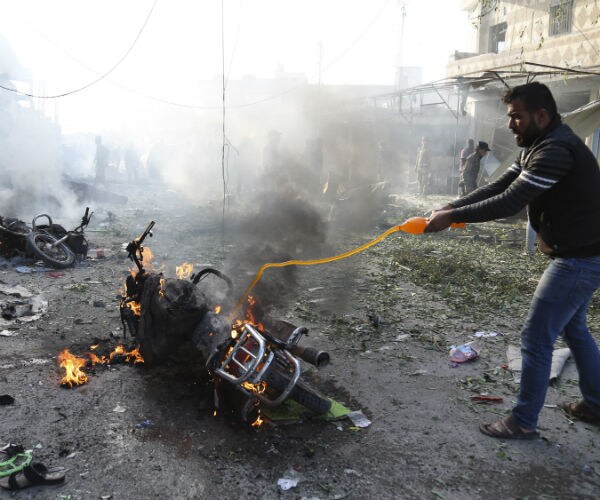 a man dowses flames on a motorcycle with a sports drink