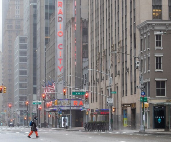 woman wearing mask walks in empty street in new york