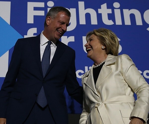 mayor Bill de  Blasio smiles with hillary clinton on stage