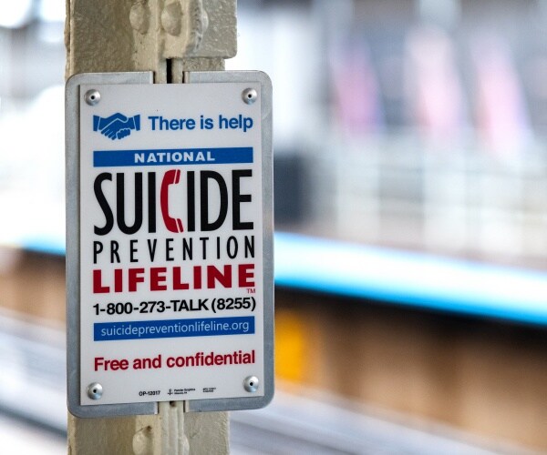 sign on poll at train station with National Suicide Prevention Lifeline