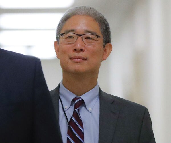 bruce ohr, wearing glasses and looking forward, walks through the halls of justice