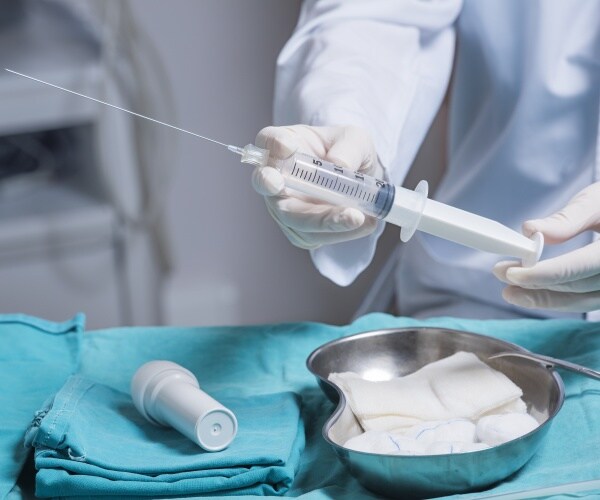 doctor holding amniocentesis needle in operating room