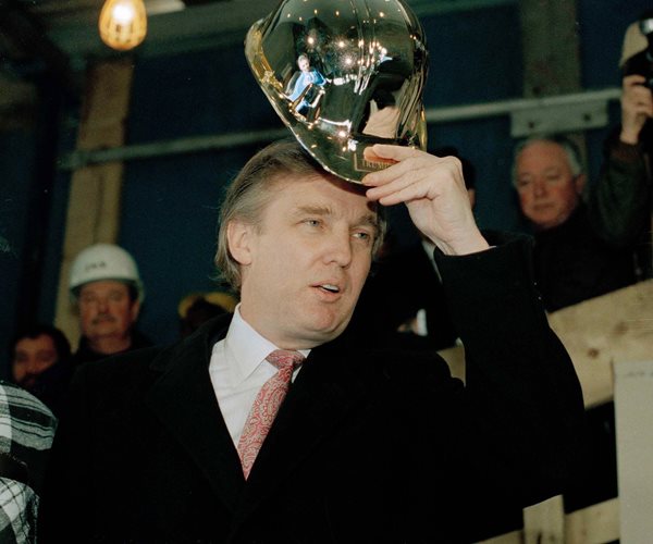 Donald Trump tries on a gold hard hat presented to him by construction workers