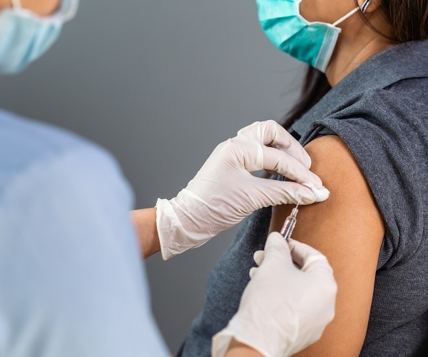 doctor holds syringe to inject patient