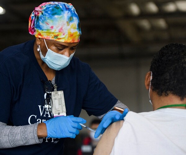 nurse administers coronavirus vaccine