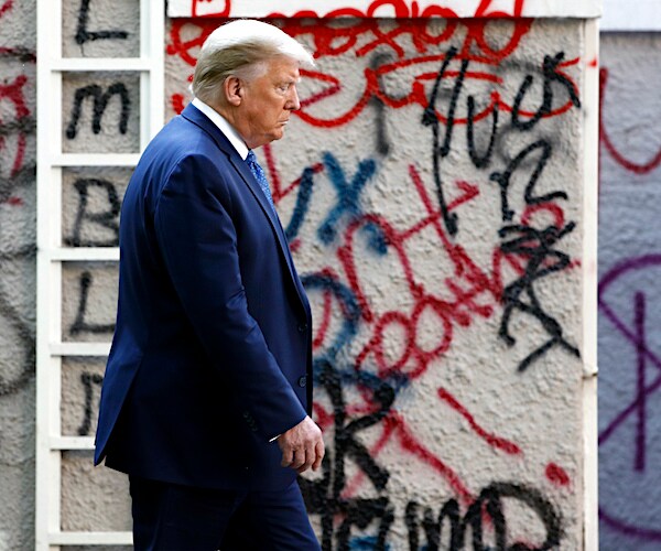 president donald trump walks past vandalized walls on his way to visit a church