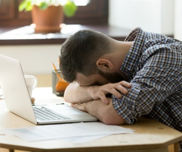 man falling asleep at work at desk