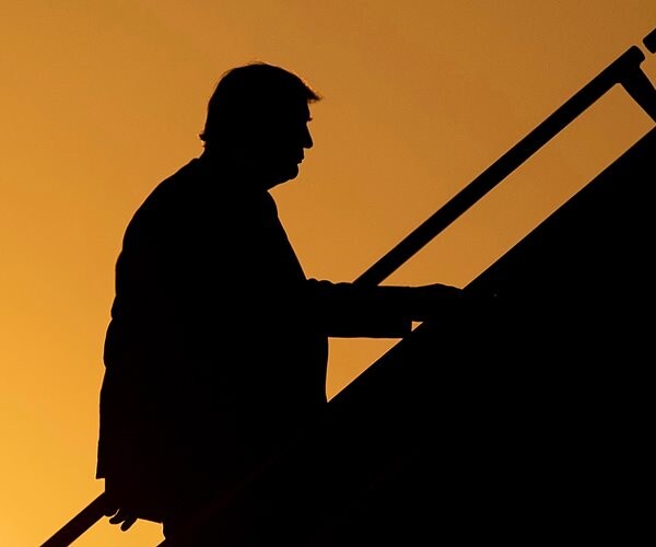 president donald trump silhouetted on the stairs of air force one