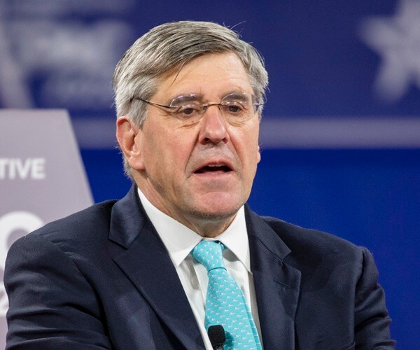 stephen moore sits on stage and speaks.