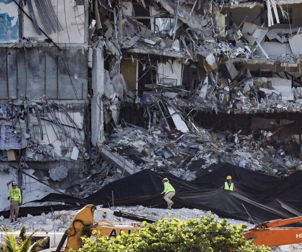 Workers seen in front of the collapsed South Florida condo building.