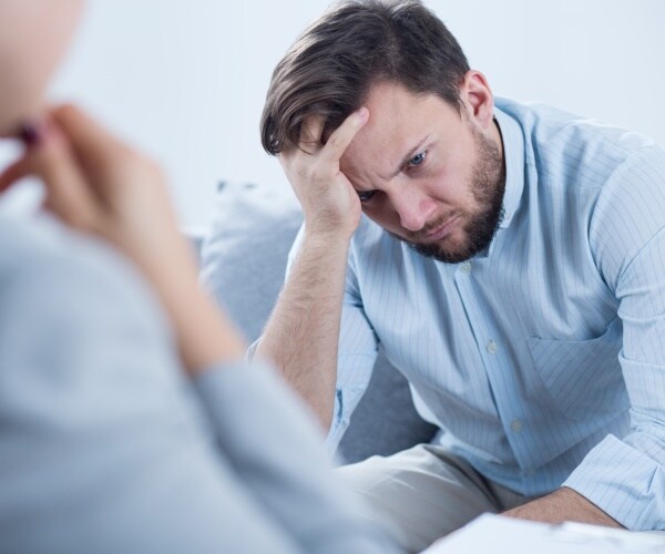 man with head in hand feeling depressed