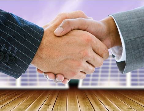 two men shaking hands with solar panels in the background