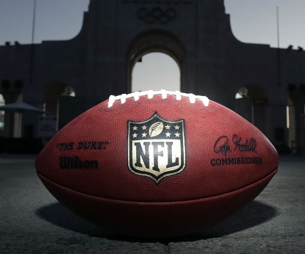 a nfl branded football sits on the field