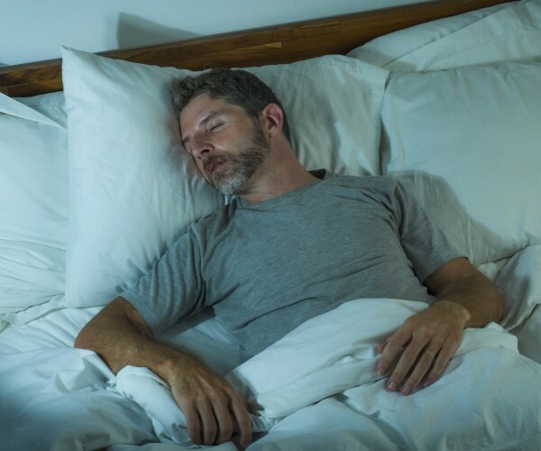 man sleeping in bed at night