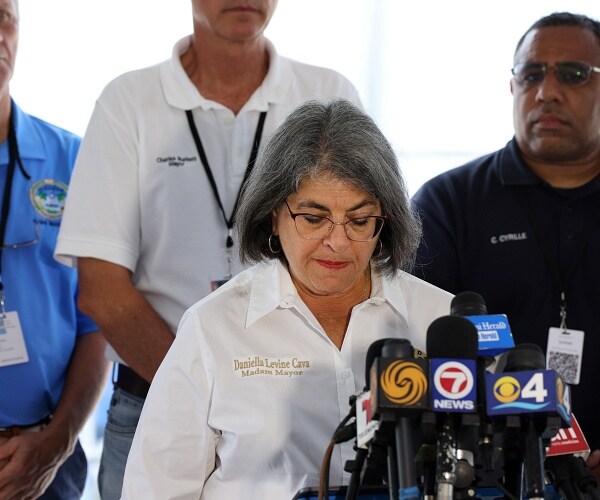 daniella levine cava bows head as she speaks into mics