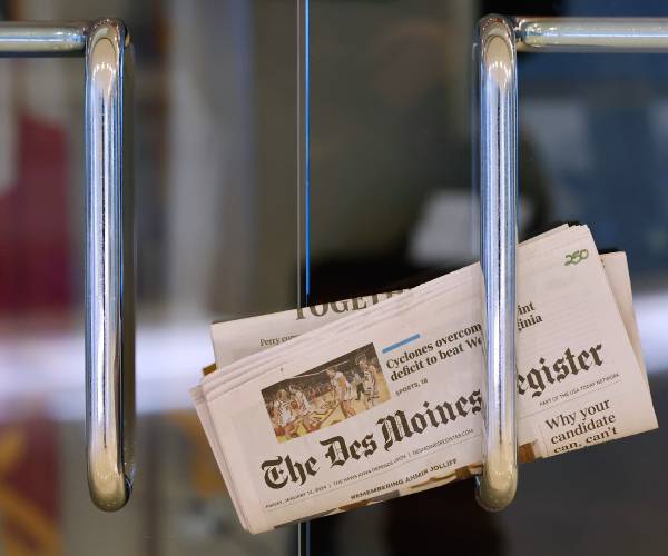 a copy of the des moines newspaper inside a door handle