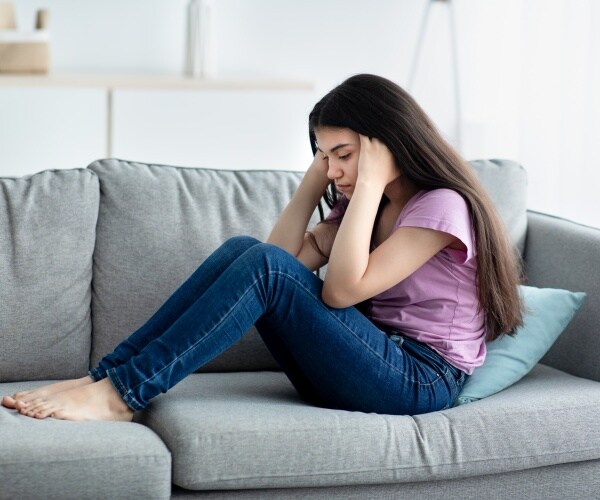 young girl on couch looking sad, depressed